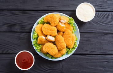 Chicken nuggets in plate on rustic background