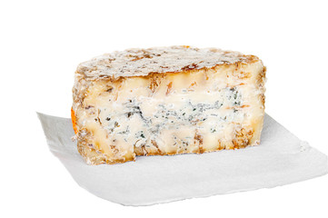A slice of blue aged delicatessen Stilton cheese on a piece of white paper. Farm quality products. Isolated