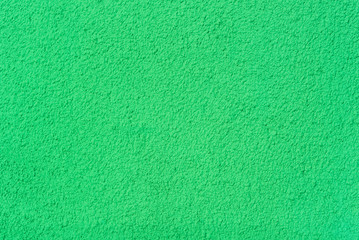  Photo of a wall with a rough texture of plaster painted in green