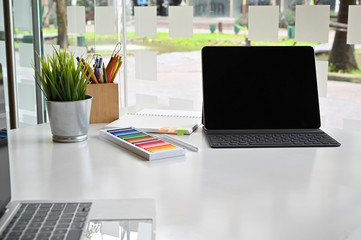 Tablet on creative desk with colour and plant decoration.