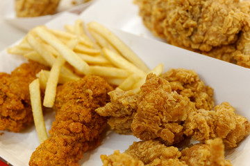 crispy fried chicken and French fries in white cardboard box