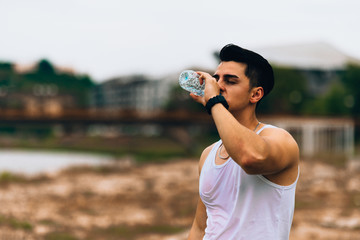 Active runner drinking water during his exercise