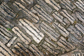Original background of natural ancient large stone with texture of cracks and bricks. The old cobblestones in Europe