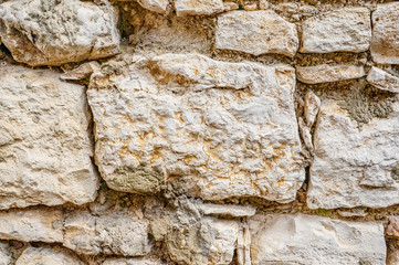 Original background of natural ancient large stone on the wall with the texture of cracks and bricks