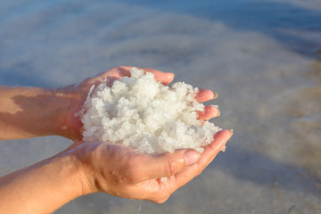 Fototapeta na wymiar A handful of salt from a salt lake. Salt mine.