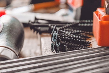 Tools for the job. Screws, nails and a screwdriver are on the table. carpentry tools.