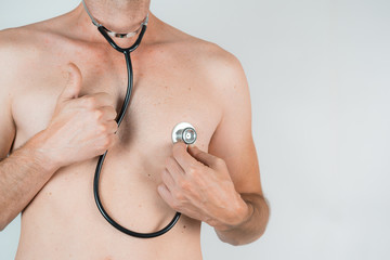 Fototapeta premium shirtless man with stethoscope and thumb up on White background