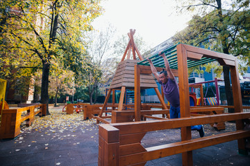 Young parkour guy doing tricks,flips and exercising at a playground.