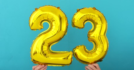 Gold foil number 23 twenty three celebration balloon on blue background