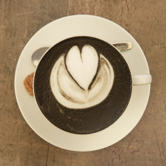 Cup of coffee with heart of love view from above