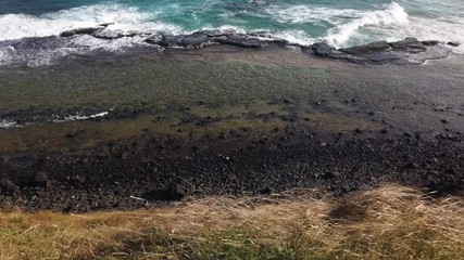 Fernando de Noronha Island, a UNESCO World Heritage site, Pernambuco, Brazil - July, 2019 - Beautiful 4k footage at Lion Beach from above of flying fields, and sea waves crashing on rocks.