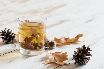 Glass of fruit tea in autumn background. Concept of autumn postcard. Copy space.