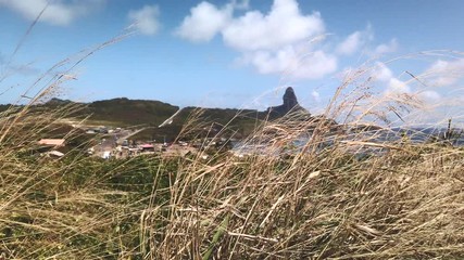 Fernando de Noronha Island, Pernambuco, Brazil - July, 2019 - Beautiful 4k footage near Saint Pedro Chapel with the view of Pico Hill and Porto de Santo Antonio beach.