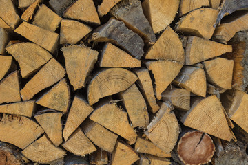 Background of dry chopped firewood laid in a woodpile. Close-up.