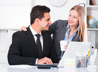 Adult business couple flirting in office