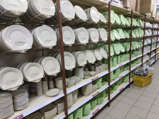 Dishes and bowls are sold on shelves in a supermarket. Organized by category to facilitate customers.