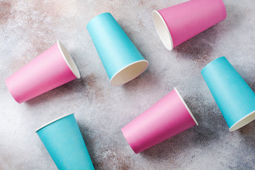 Pattern of pink and blue paper cup of coffee on old light background. Zero waste concept. Flat lay.