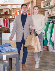 Young woman and man are walking satisfied with packadge after shopping