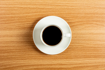 white ceramic coffee cup on wooden desk. - blank space for advertising text.