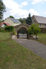 Fototapeta na wymiar Zabytkowe kamienne wejscie na teren kościoła parafialnego we wsi Lipa, powiat jaworski, Polska
