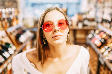 portrait of a stylish girl in sunscreen. modern interior of the wine bar.