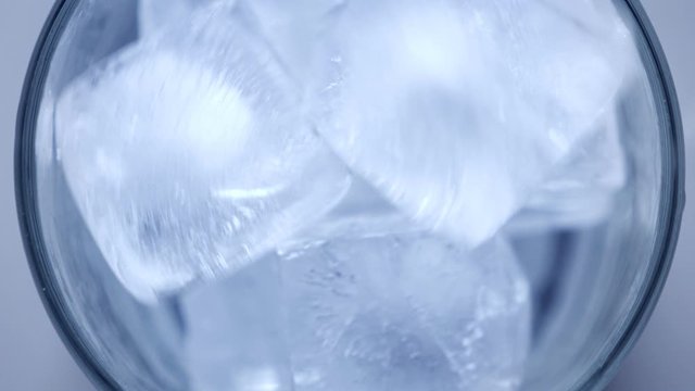 Throw ice cubes in empty glass. Icecubes falling down in cup