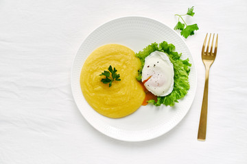 Poached egg and polenta with lettuce salad, fodmap diet, top view copy space closeup