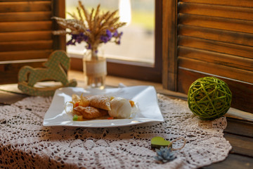 cake on a white plate on an embroidered napkin on the windowsill