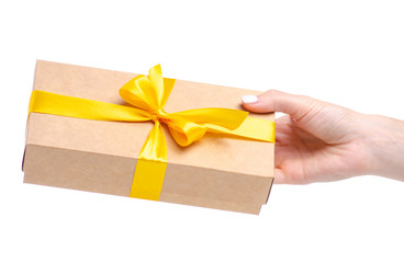 Box with yellow ribbon bow gift in hand on white background isolation