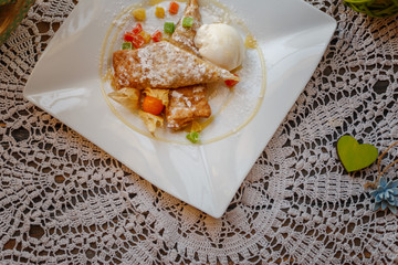 cake on a white plate on an embroidered napkin on the windowsill