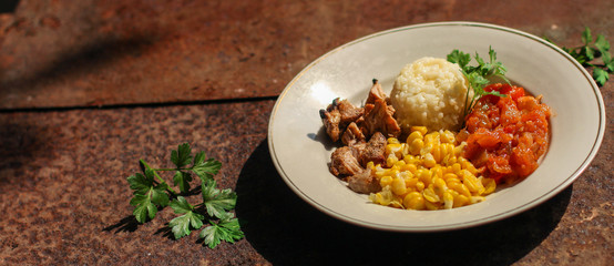 rice with meat and vegetables (tomato, corn, onions and other ingredients) top concept. food background. copy space