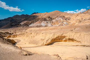 A dry river on the Artist's Drive crossing and in the background Artist Point in Death Valley, California. United States