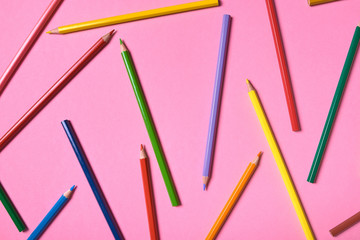 Color pencils on pink pastel background, close up. Set of colorful pencils, copy space. Crayons. Top view, flat lay. Back to school, college concept. Abstract background