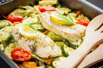 Cod fillet on paprika, onion with zucchini and cheese