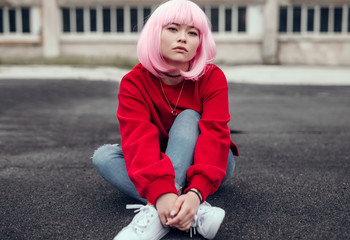 Asian hipster sitting on ground on street