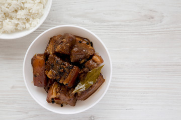 Homemade Filipino Adobo Pork with rice on a white wooden background, top view. Flat lay, overhead, from above. Copy space.