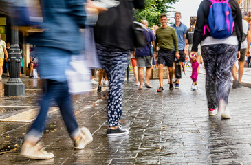 Menschen in einer Einkaufsstraße kurz nach dem Regen