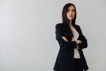 Young attractive emotional girl in business-style clothes on a plain white background in an office or audience