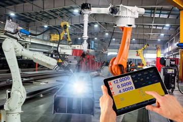 Engineer check and control welding robotics automatic arms machine in intelligent factory...