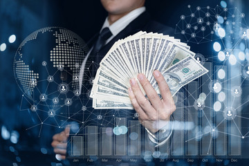 Businessman showing banknotes on the background of financial growth.