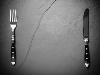 Black slate plate with steak cutlery, place for text