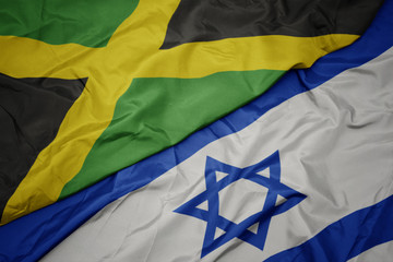 waving colorful flag of israel and national flag of jamaica.