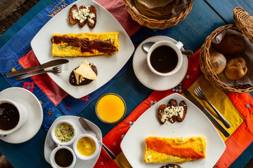 colorida mesa de desayuno preparada con cafe, tortillas omelet, aderezos y jugo