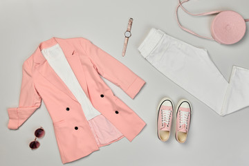 Fall fashion Flat lay. Trendy coral jacket, Stylish trousers, hipster sneakers. Creative autumn Woman Clothes Accessories layout. Fall Girl fashionable Outfit, autumnal pastel pink color.