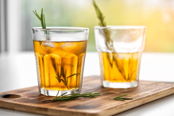 glasses of soda with lemon and rosemary on a bamboo board
