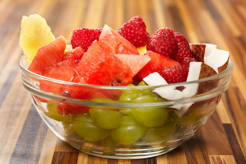 Fruit healthy salad made of grapes, watermelon, raspberry, pineapple and coconut