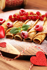 Delicious Tasty Homemade crepes or pancakes with raspberries and mint on rustic background