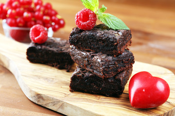 chocolate brownie cake dessert with raspberry and spices on a rustic background