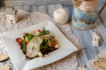 beetroot,tomato,pear and green salad with cheese on a white plate