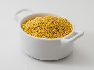 Dry millet groats in ceramic bowl